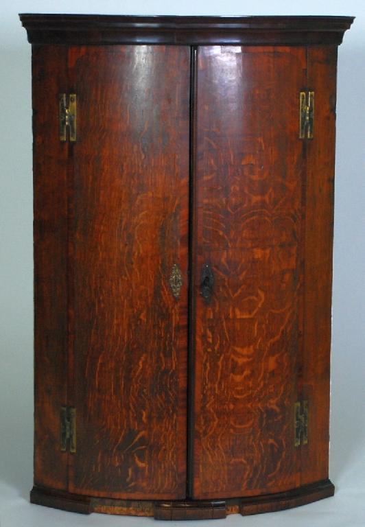 Appraisal: GEORGE III MAHOGANY CROSSBANDED OAK BOW FRONTED CORNER CUPBOARD the