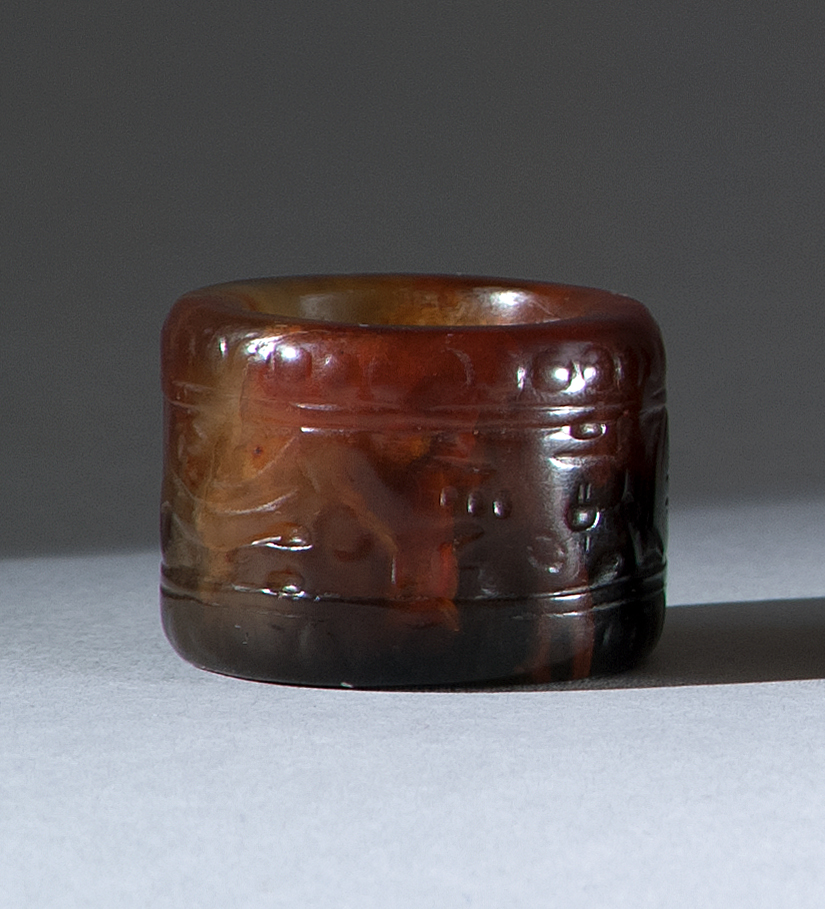 Appraisal: RED AND BLACK TRANSLUCENT SOAPSTONE THUMB RING th CenturyWith stylized