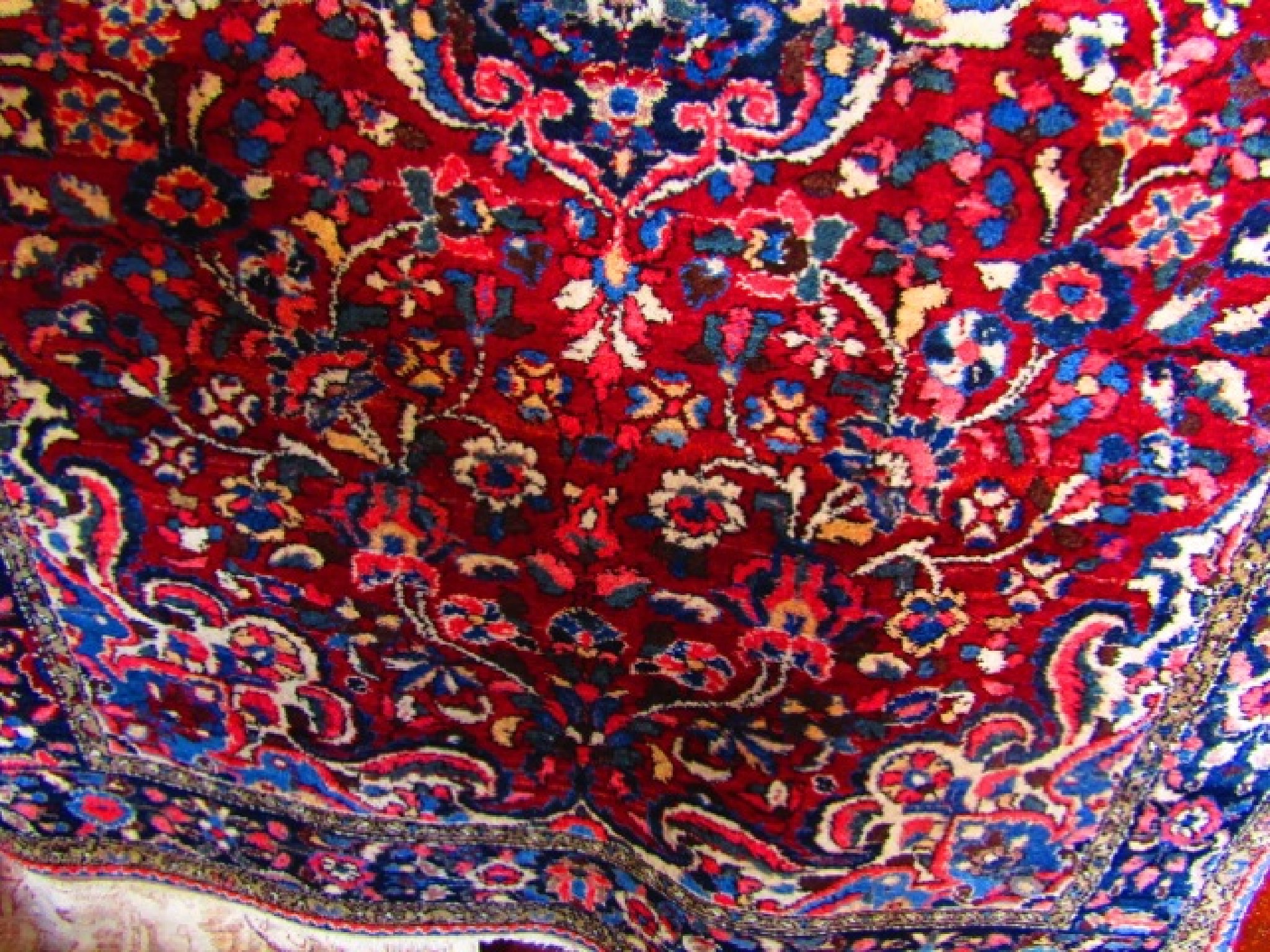 Appraisal: An eastern wool carpet with deep red field decorated with