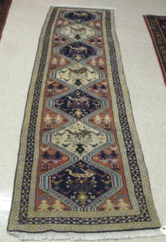 Appraisal: PERSIAN RUNNER with stylized bird animal and human figures decorating