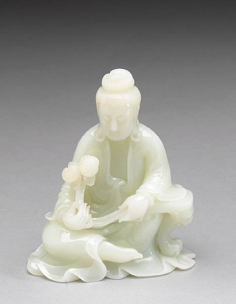 Appraisal: A white jade model of Guanyin Shown holding a lotus