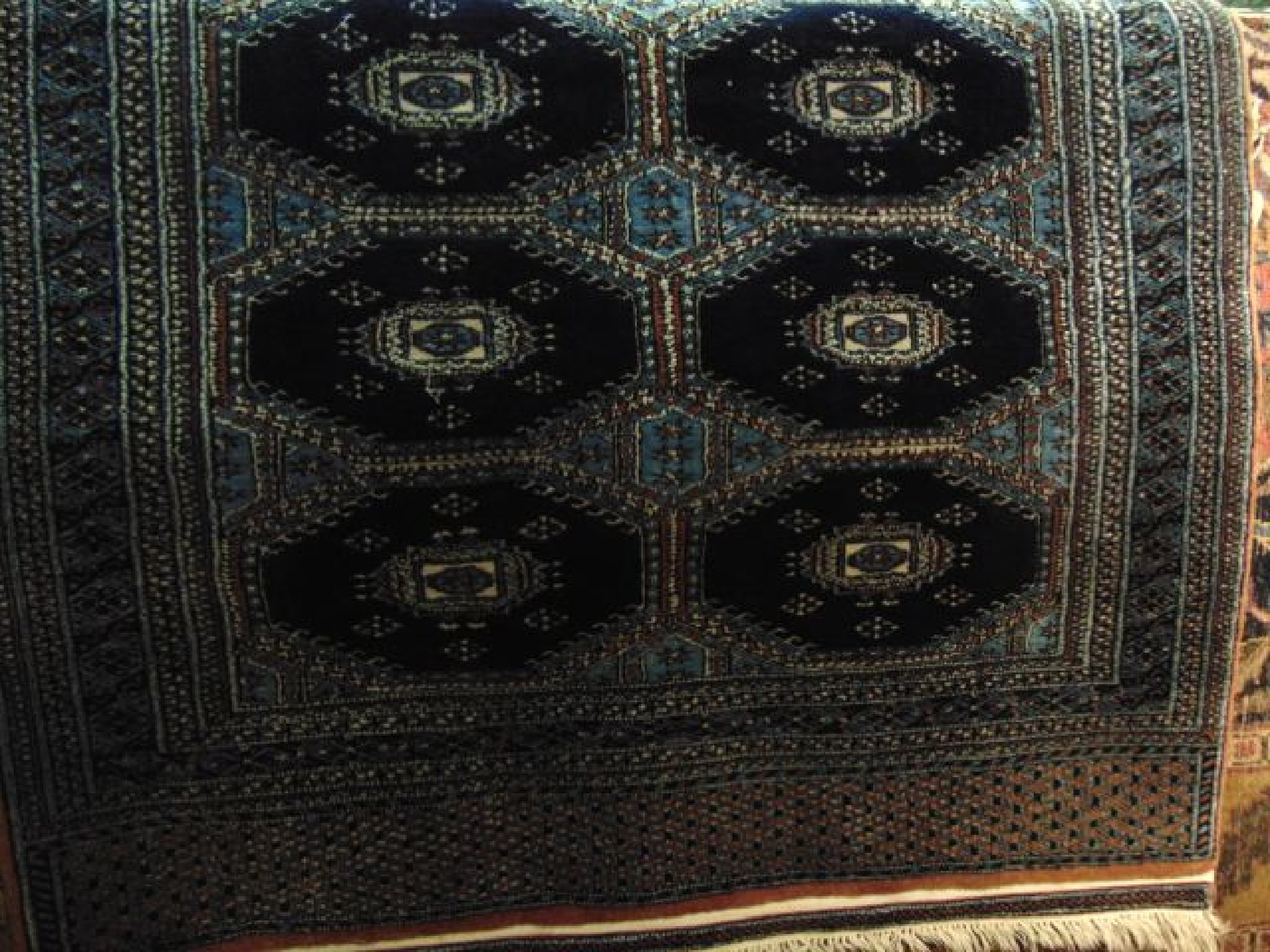 Appraisal: A Persian wool rug with multi-medallion panels upon a deep