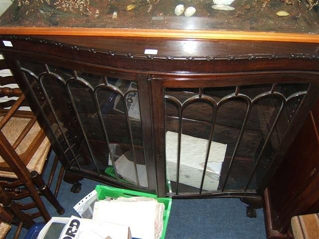 Appraisal: An Edwardian mahogany serpentine display cabinet the glazed doors enclosing