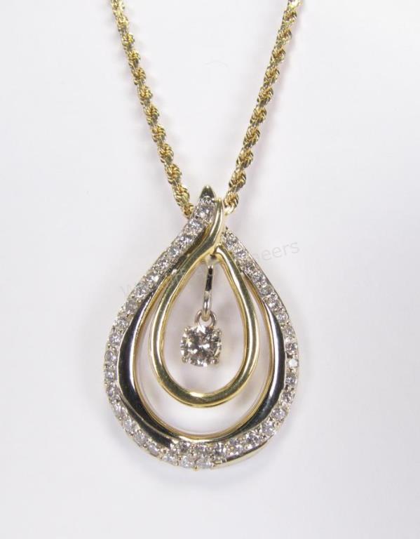 Appraisal: A K white and yellow gold pear shaped pendant with