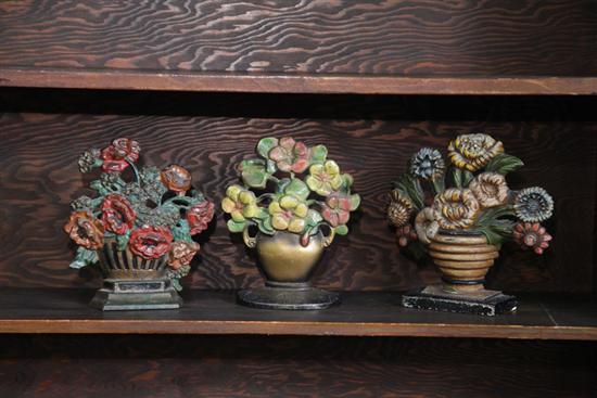 Appraisal: THREE PAINTED CAST IRON FIGURAL DOORSTOPS Each depicting polychrome flowers