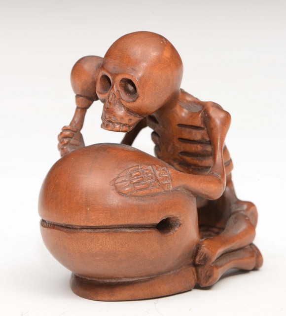 Appraisal: A CARVED BOXWOOD NETSUKE A skeleton striking a large bell