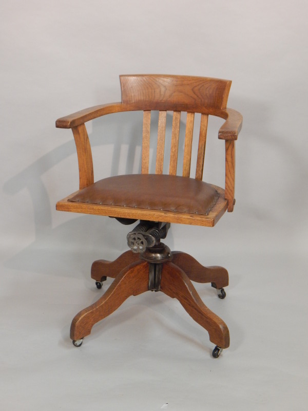 Appraisal: An early thC oak revolving office chair with a brown