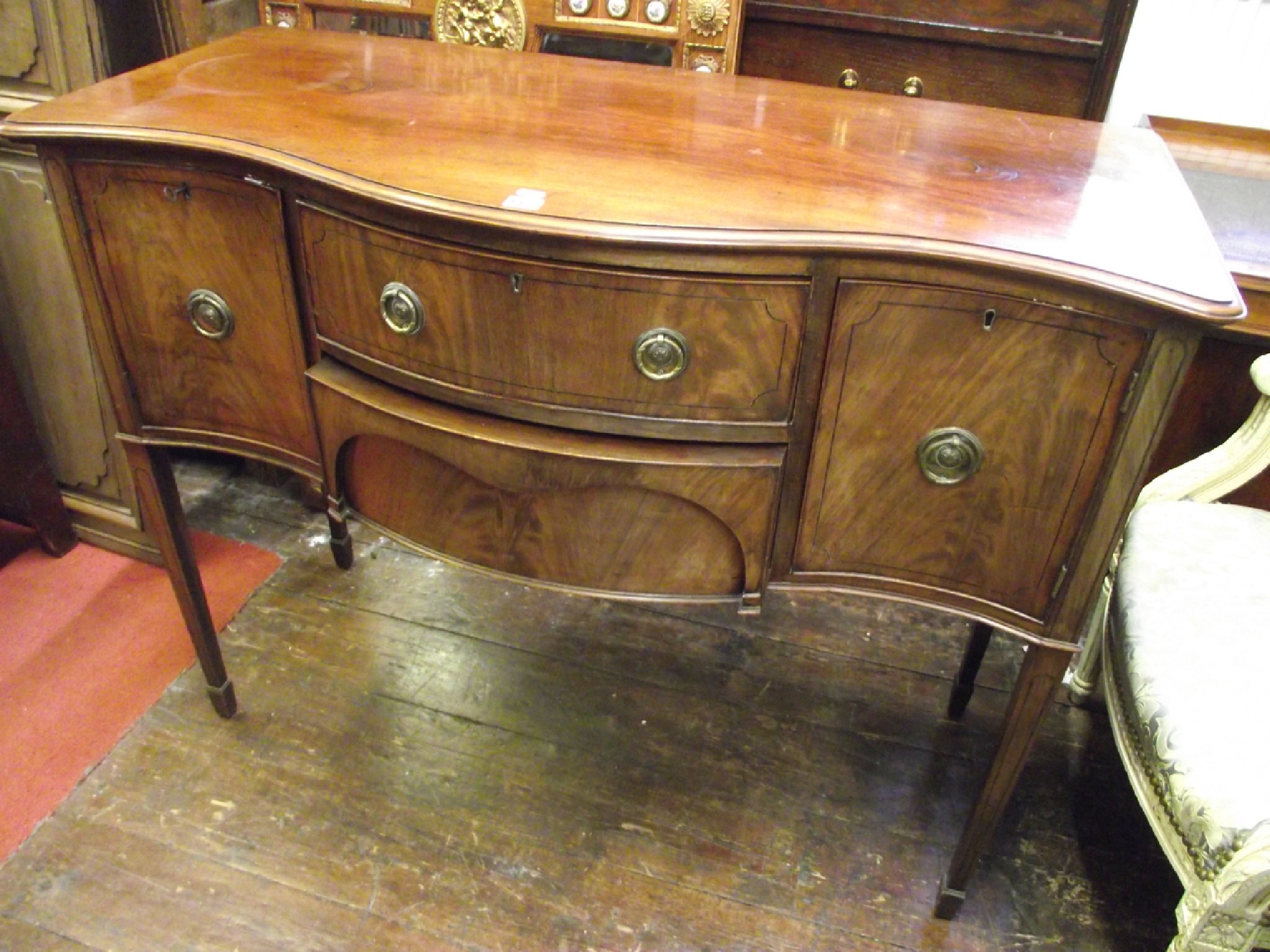 Appraisal: A small Georgian style mahogany serpentine sideboard the two central