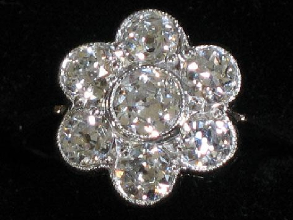 Appraisal: A DIAMOND DRESS RING of flowerhead design millegrain set a