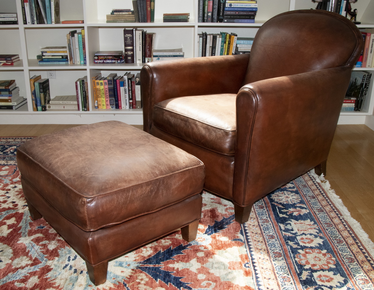 Appraisal: BROWN LEATHER ARMCHAIR WITH OTTOMAN Leather upholstered arm chair with