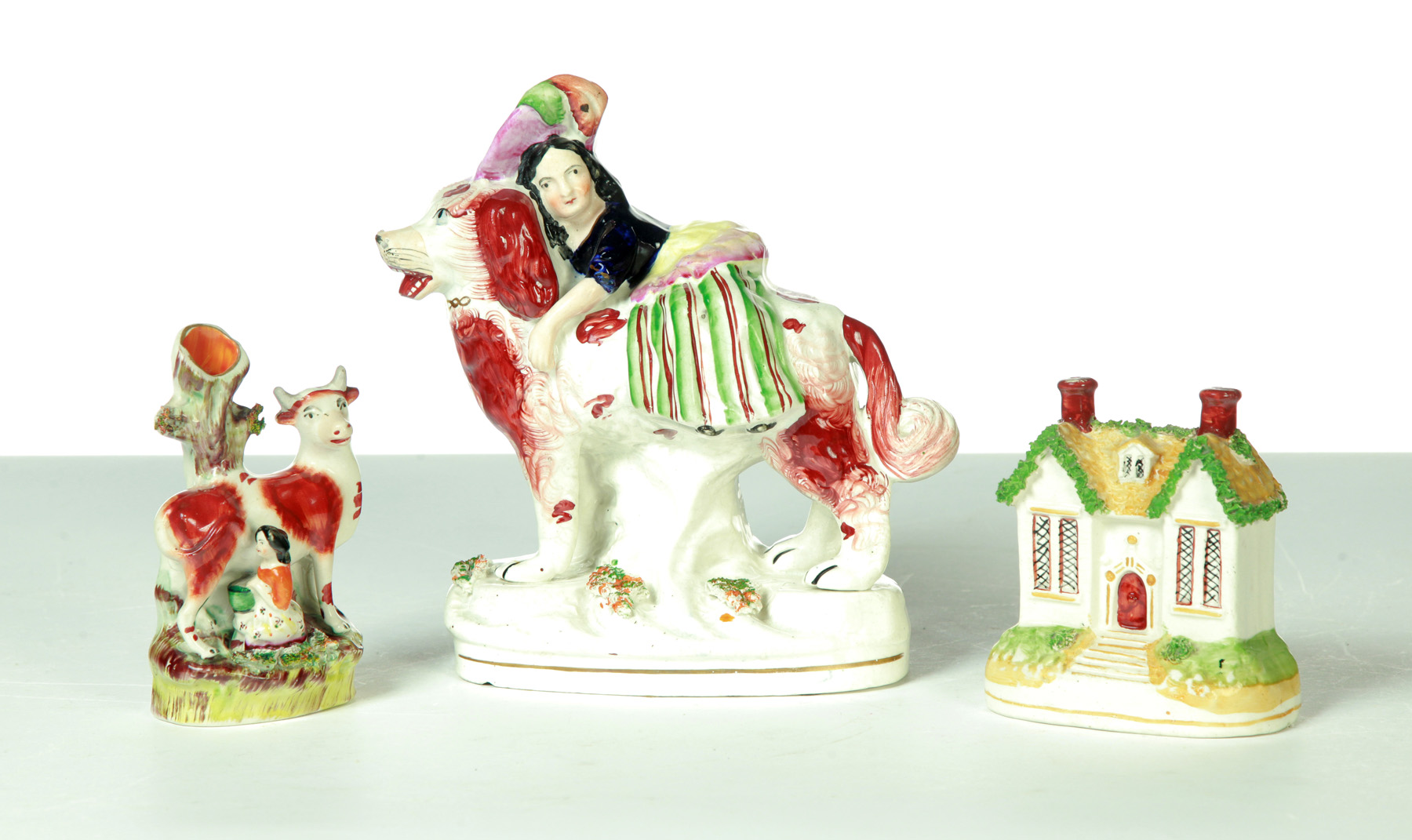 Appraisal: THREE FIGURAL STAFFORDSHIRE PIECES England mid th century Girl riding