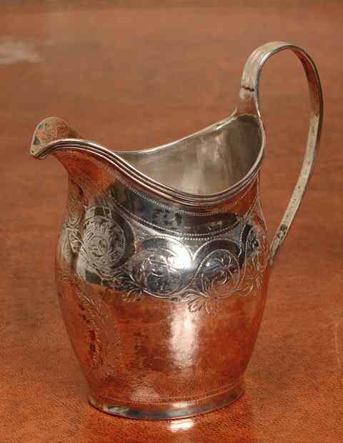 Appraisal: A GEORGE III SILVER HELMET SHAPED CREAM JUG with engraved