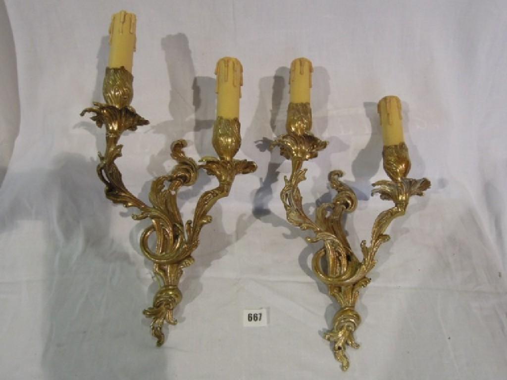 Appraisal: Thirteen gold ormolu effect scrolled wall lights each with two