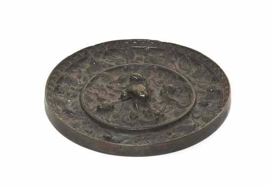 Appraisal: A Chinese Bronze Mirror having central lion form cord loop