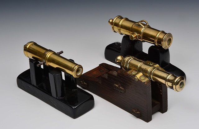 Appraisal: THREE BRASS TABLE TOP CANNONS each mounted on wooden carriages