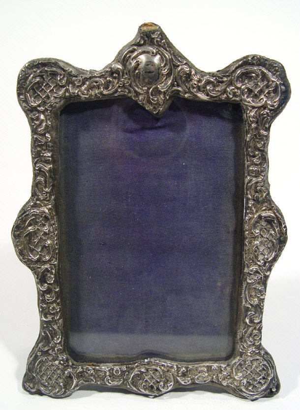 Appraisal: Shaped rectangular silver photo frame with embossed decoration indistinctly hallmarked