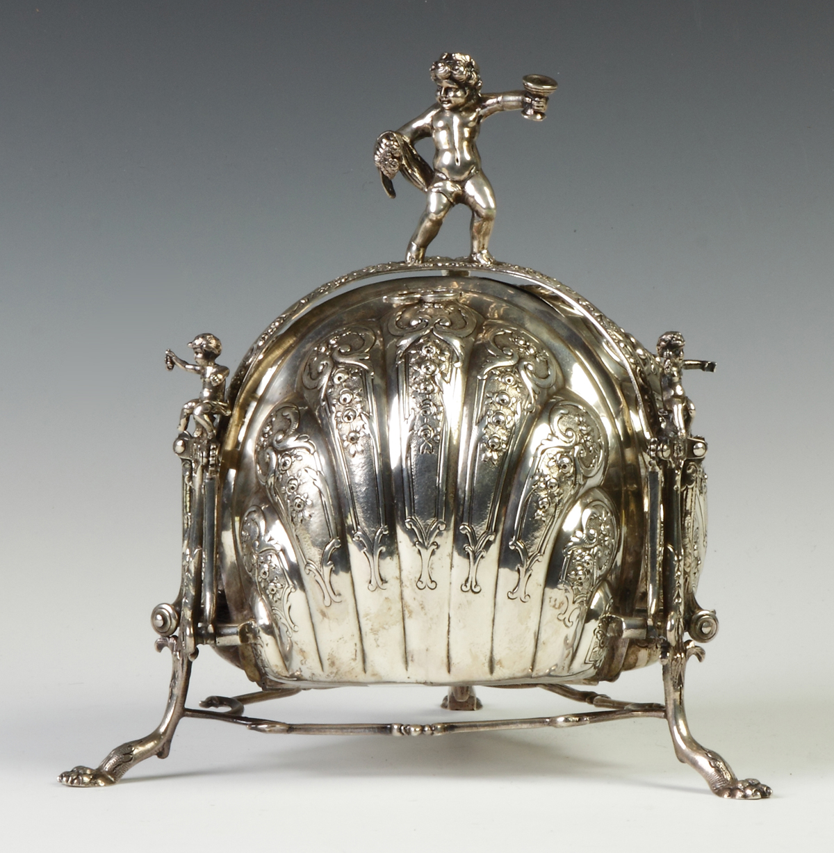 Appraisal: German Silver Mechanical Folding Biscuit Box silver Melon shaped cherubs