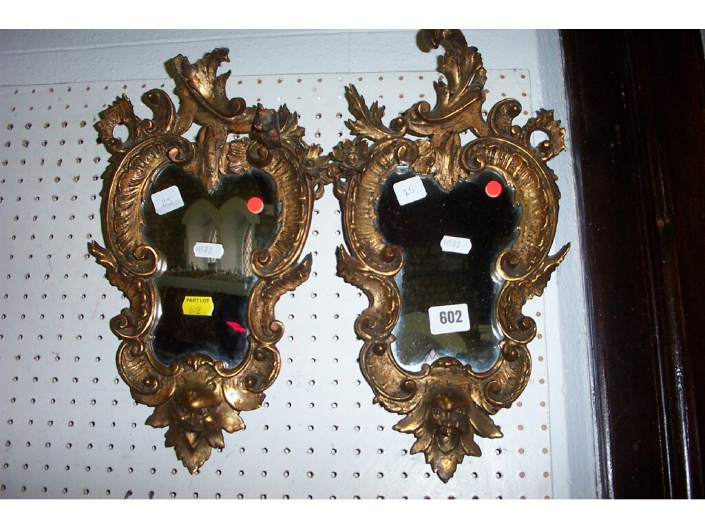 Appraisal: A pair of rococo style wall mirrors of shaped and