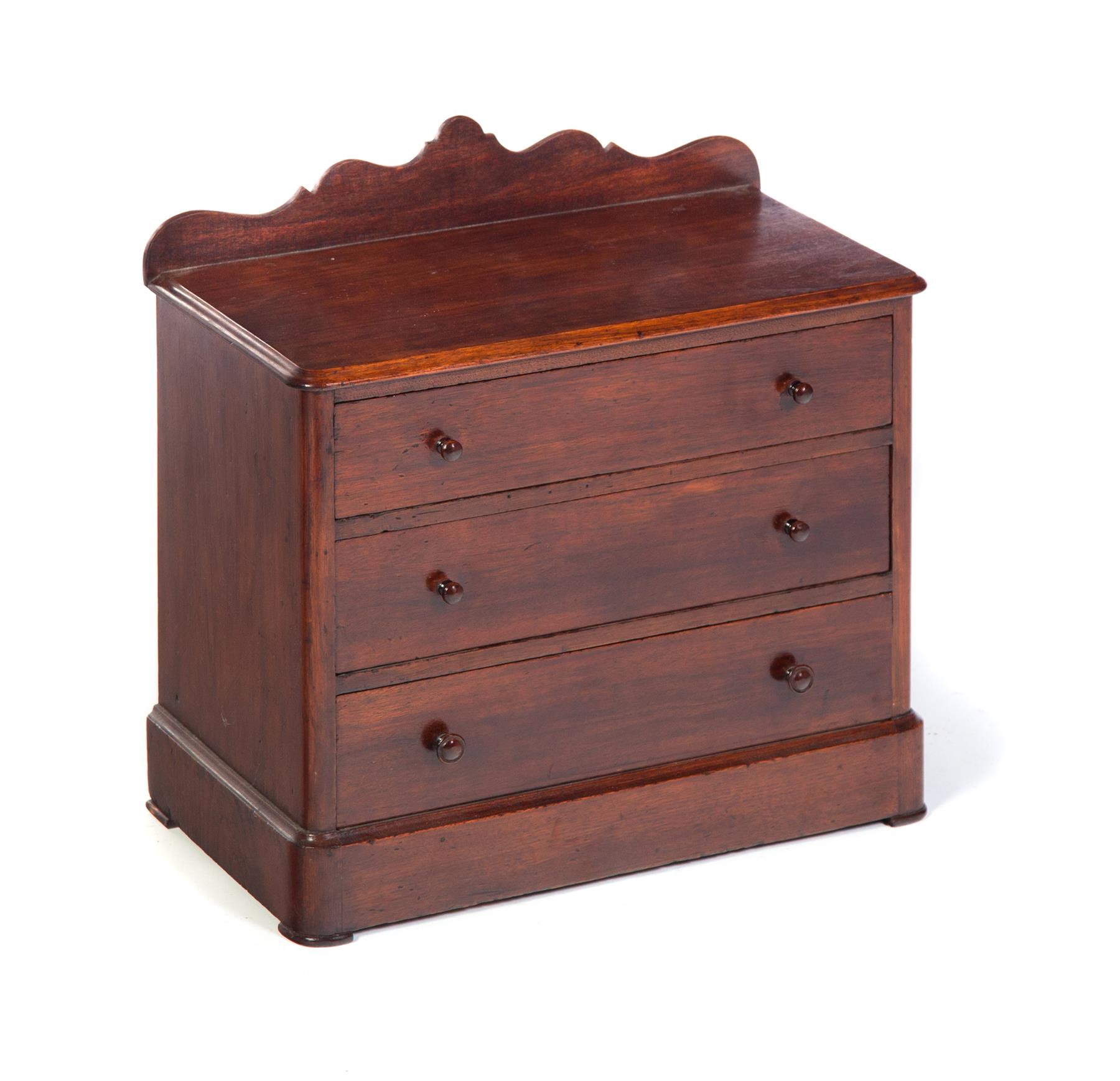 Appraisal: MINIATURE THREE-DRAWER CHEST American rd quarter- th century mahogany with