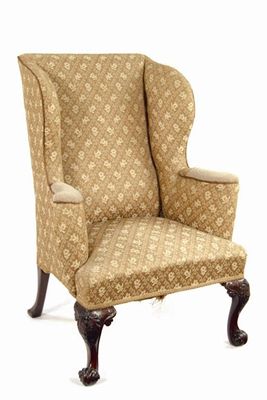 Appraisal: A carved mahogany wing armchair on patera capped front cabriole