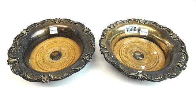 Appraisal: A pair of Victorian plated bottle coasters each of shaped