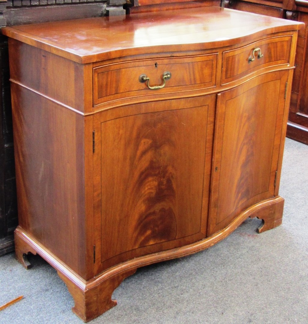 Appraisal: A George III style mahogany serpentine side cupboard on bracket