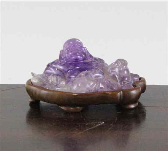 Appraisal: A Chinese amethyst quartz reclining figure of Budai wood stand