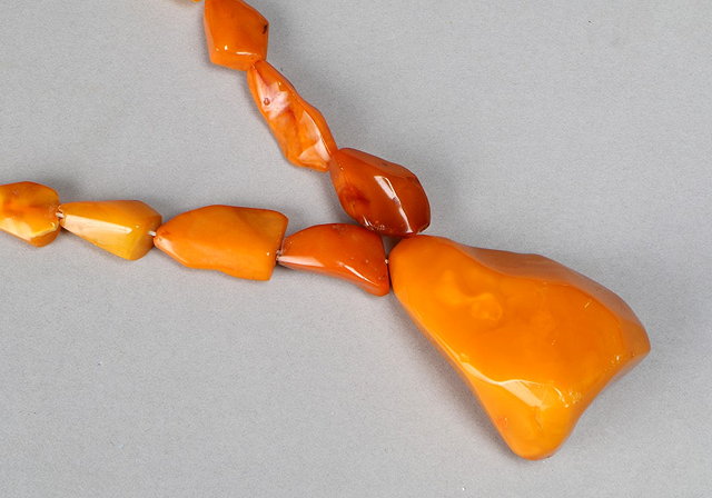 Appraisal: A GRADUATED AMBER BEAD NECKLACE AND PENDANT irregular triangular shaped