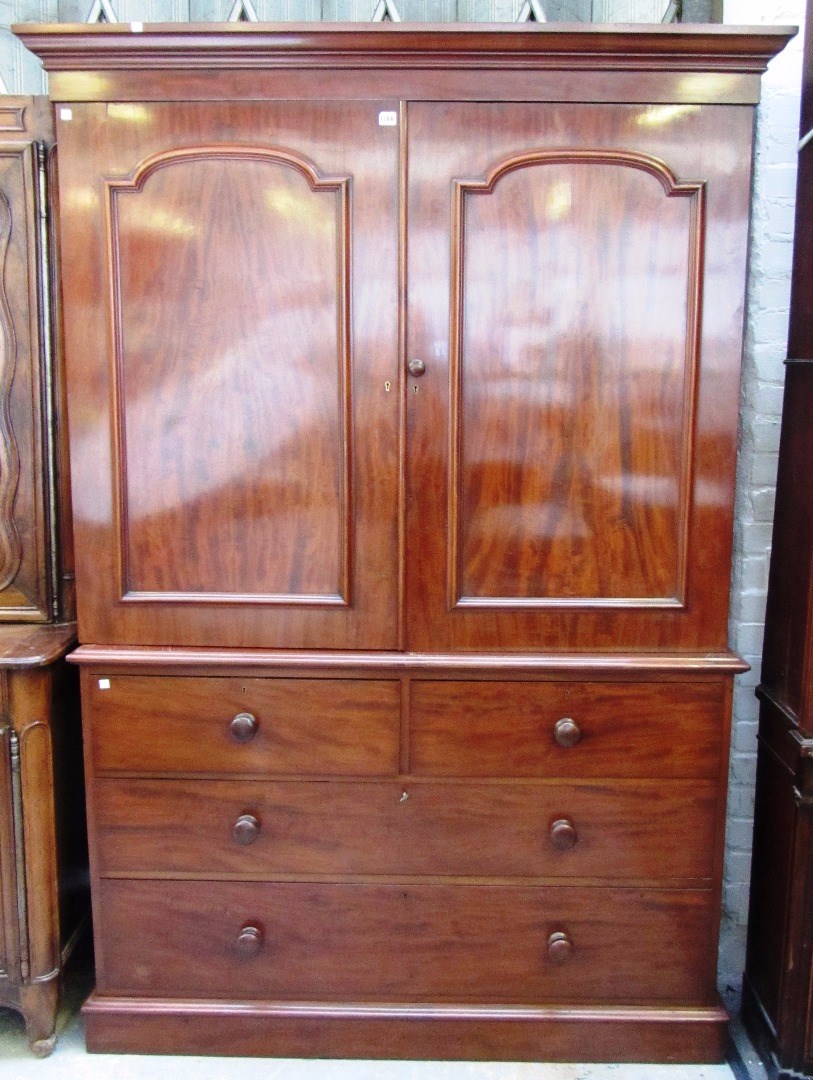 Appraisal: A Victorian mahogany linen press the arched panel doors enclosing