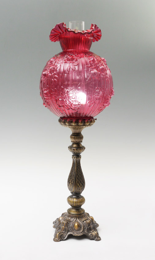 Appraisal: CRANBERRY GLASS SHADE TABLE LAMP Patinated cast metal base embossed