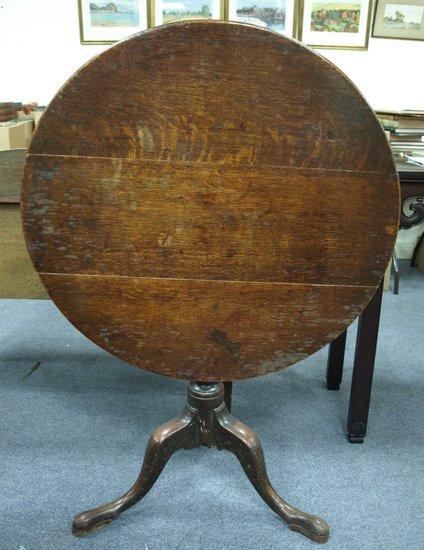 Appraisal: A George III oak tripod table the circular top on