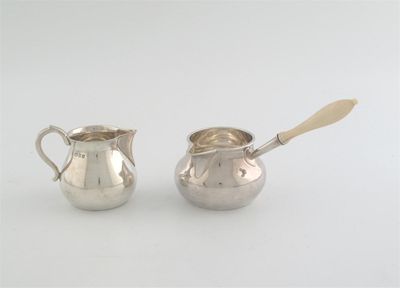 Appraisal: An Edwardian Britannia standard brandy saucepan with a turned ivory