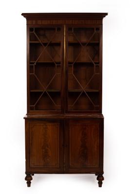 Appraisal: A mahogany bookcase enclosed by a pair of astragal glazed