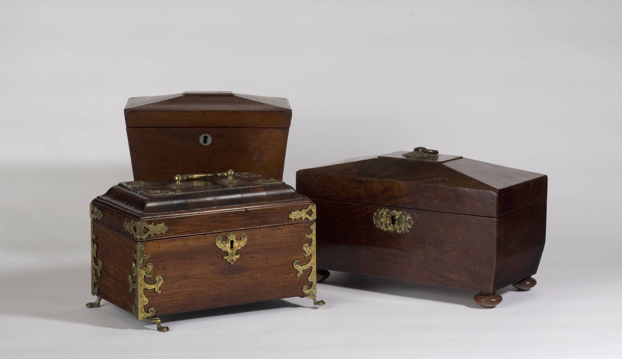 Appraisal: TWO ENGLISH MAHOGANY SARCOPHAGUS-FORM TEA CADDIES AND A COLONIAL BRASS-BOUND