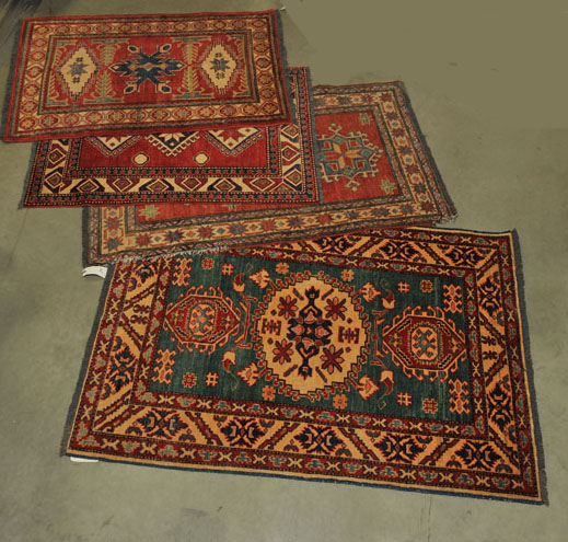 Appraisal: FOUR ORIENTAL STYLE RUGS Each having multiple borders with foliate