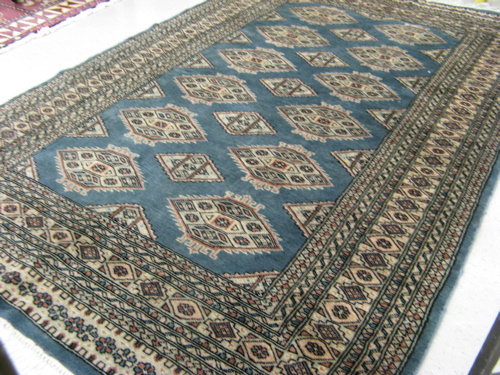 Appraisal: A PAKISTANI BOKHARA AREA RUG the blue-gray field decorated with