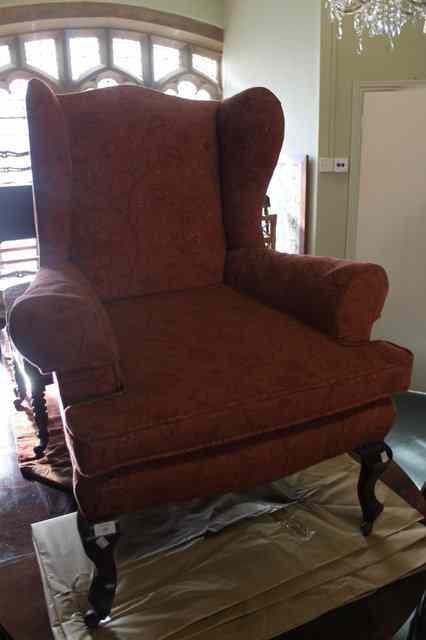 Appraisal: A WINGBACK ARMCHAIR on mahogany short cabriole legs