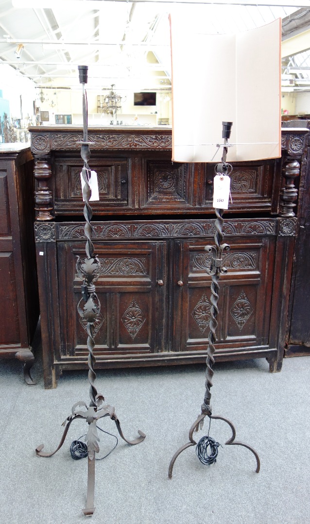 Appraisal: Two wrought iron standard lamps of Medieval style each with