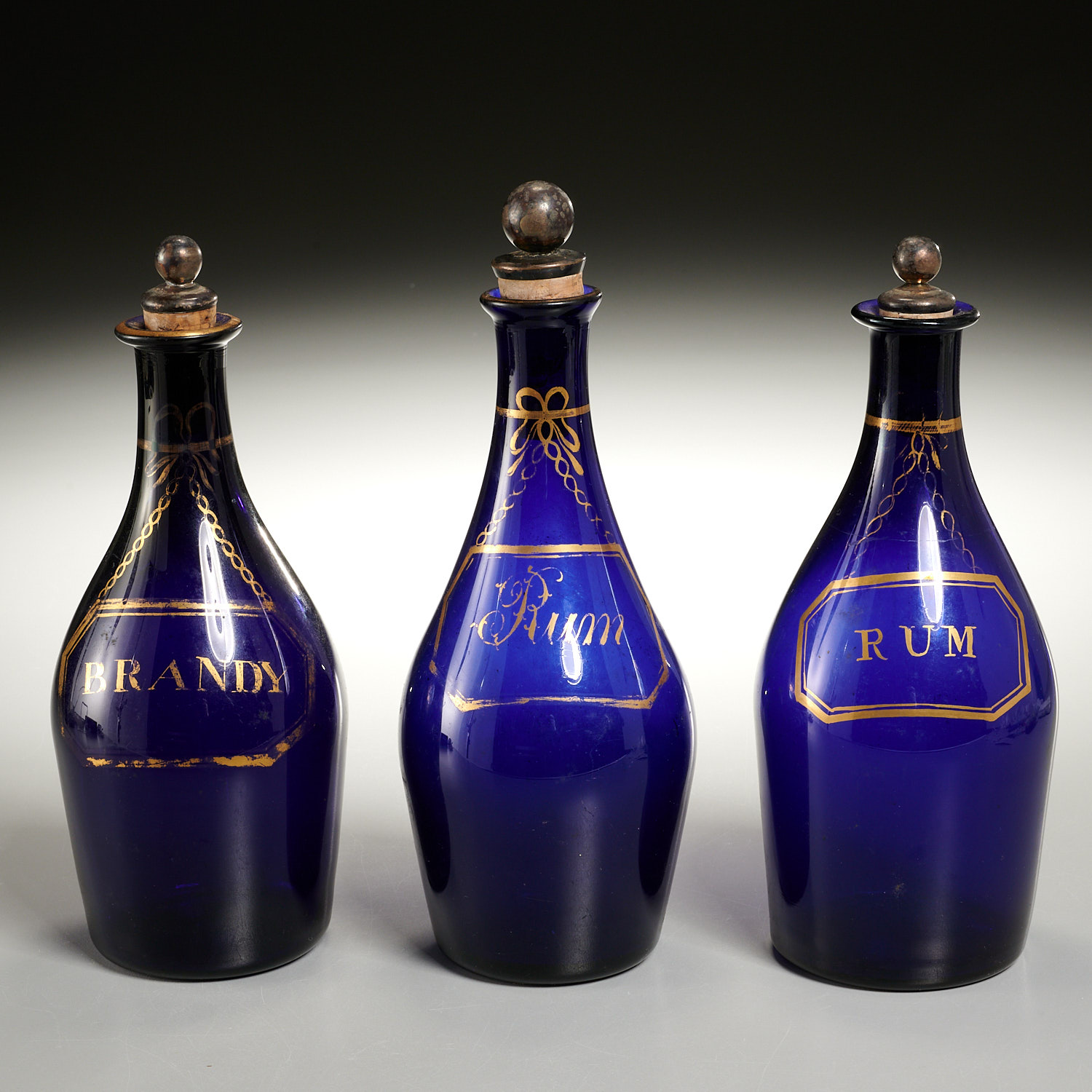 Appraisal: GEORGE III COBALT-BLUE GLASS DECANTER BOTTLES c gilt decorated and