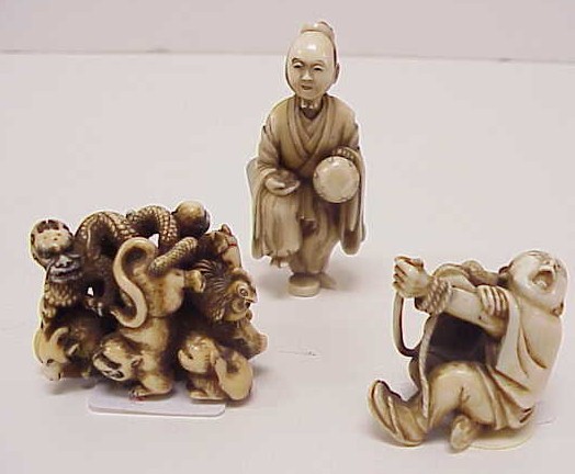 Appraisal: Three Japanese ivory carvings early th C including a cluster