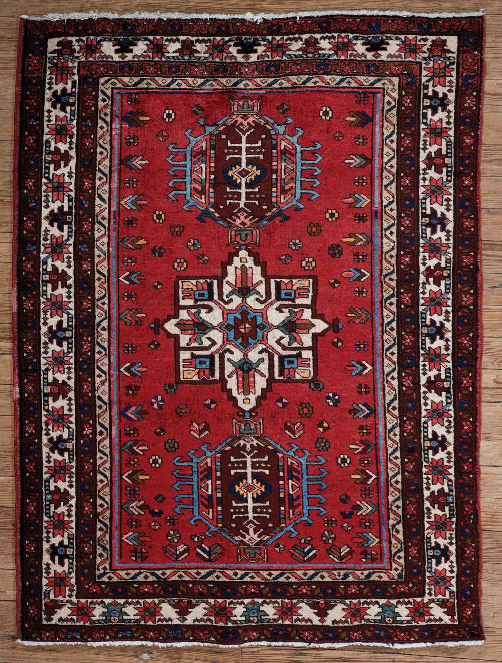 Appraisal: Persian Heriz Carpet red ground triple medallions ft in x