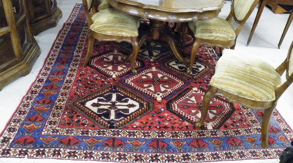 Appraisal: PERSIAN TRIBAL CARPET featuring large geometric medallions on red field