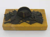 Appraisal: A yellow marble paperweight with bronze cast of military trophies