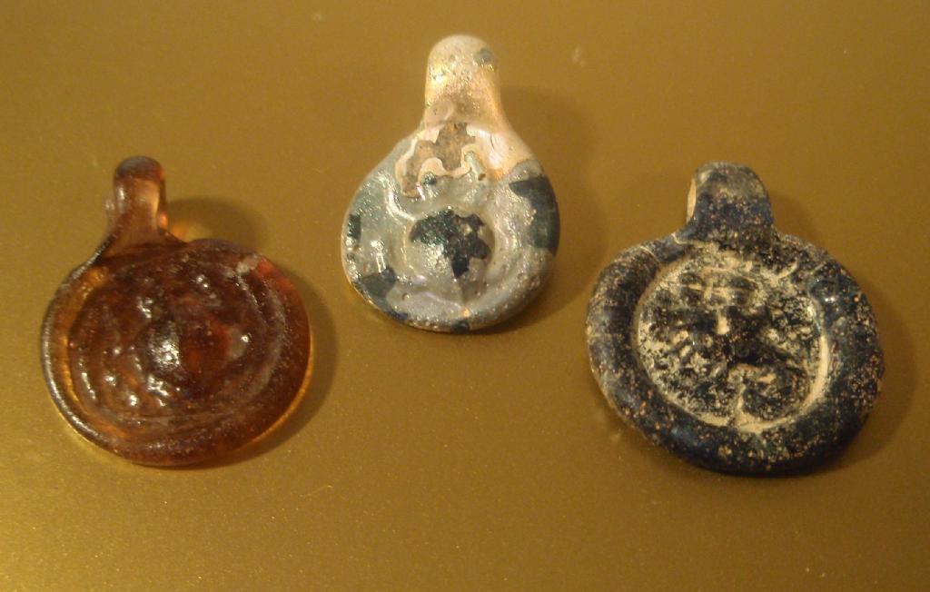 Appraisal: Three impressed Byzantine glass amulets pale purple with a turtle