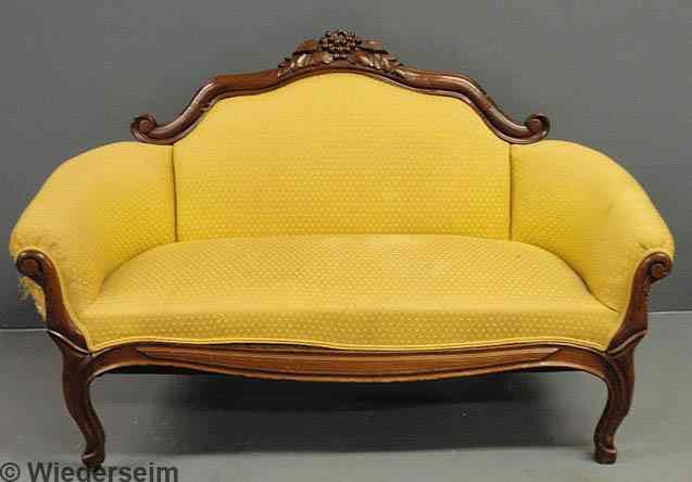 Appraisal: Victorian walnut child's sofa with carved crest rail and yellow