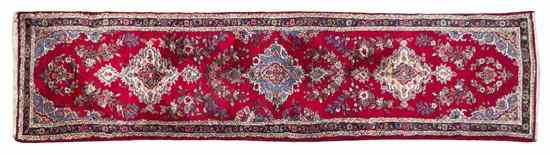 Appraisal: A Kirman Wool Runner with repeating foliate medallions on a