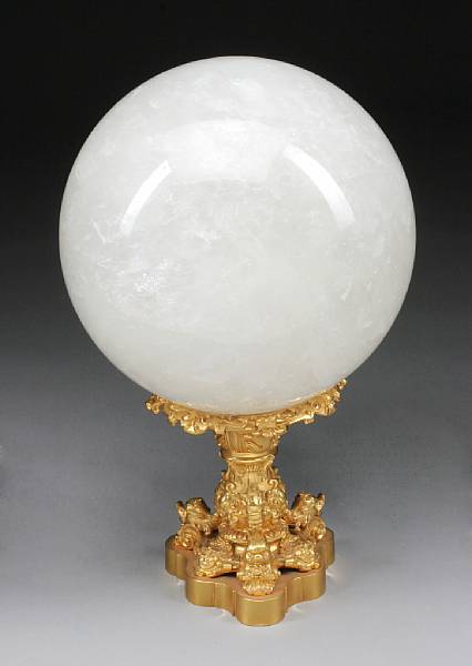 Appraisal: A rock crystal sphere on gilt bronze base The orb