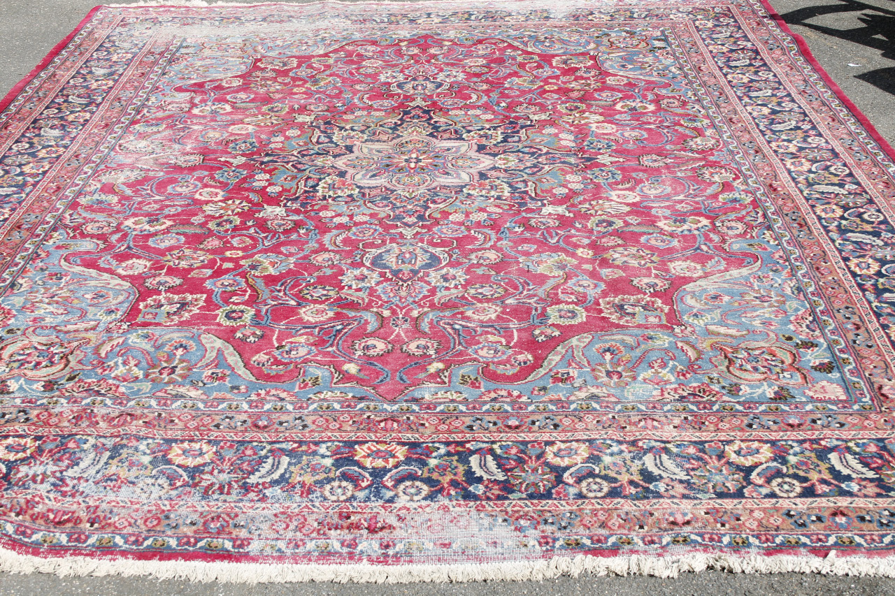 Appraisal: A large thC rug in floral pattern predominantly in red