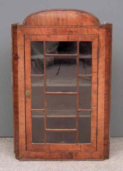 Appraisal: An th Century walnut hanging corner cupboard with arched cresting