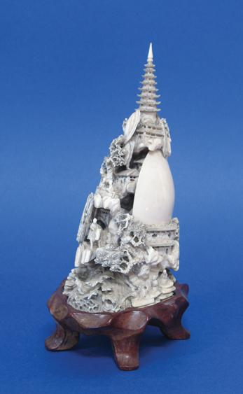 Appraisal: A CHINESE IVORY MOUNTAIN carved with pine trees figures pavilions